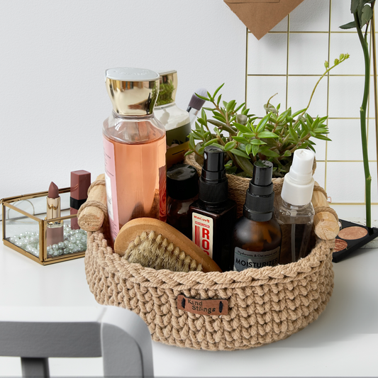Bathroom counter with a gray woven basket containing skincare products, a small plant, and brushes.