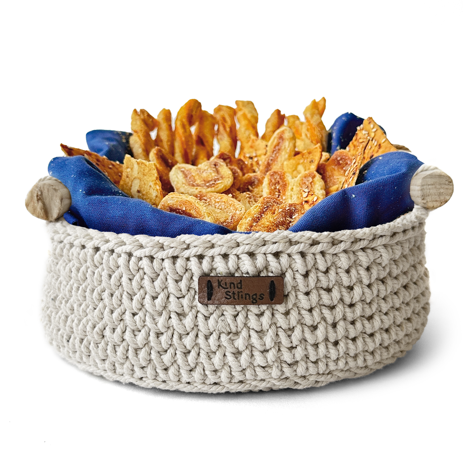 Crocheted basket with snacks and a blue cloth on a white background