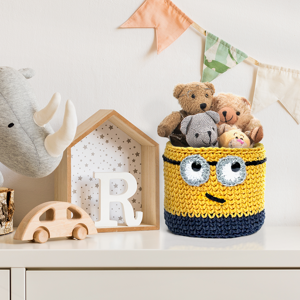 Crocheted minion basket with stuffed toys on a shelf in a child's room