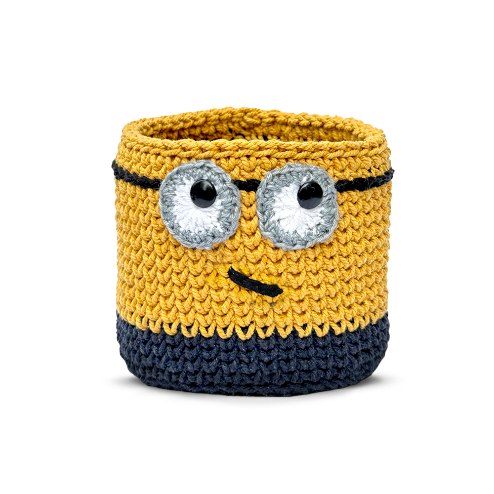 Knitted minion-style Basket with googly eyes on a white background