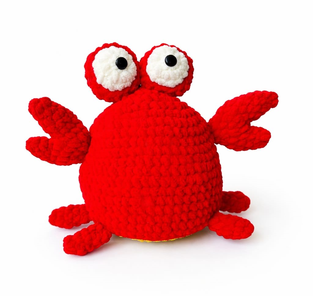 Red crochet crab toy on a white background