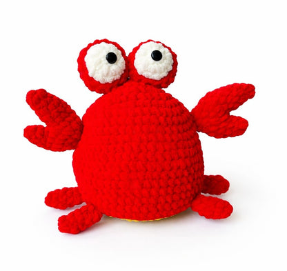 Red crochet crab toy on a white background
