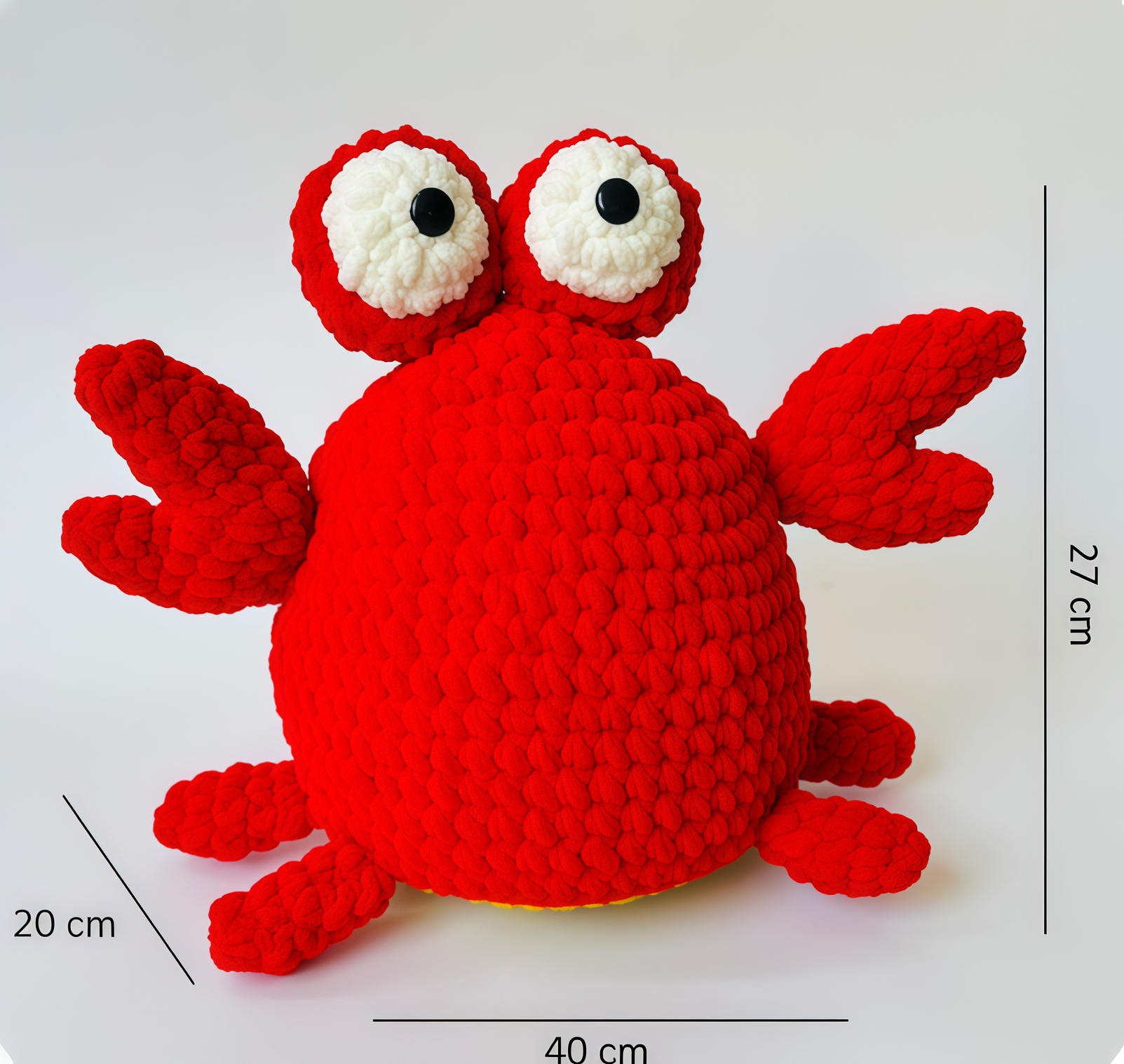 Red crochet crab toy with measurement labels on a white background
