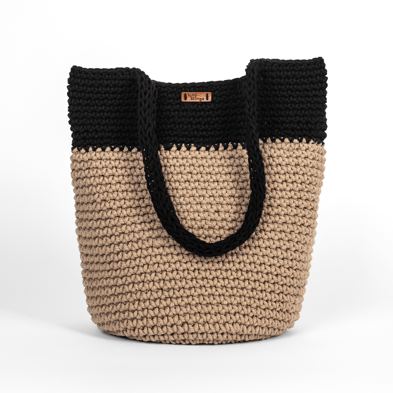 Two-toned black and beige woven bag on a white background