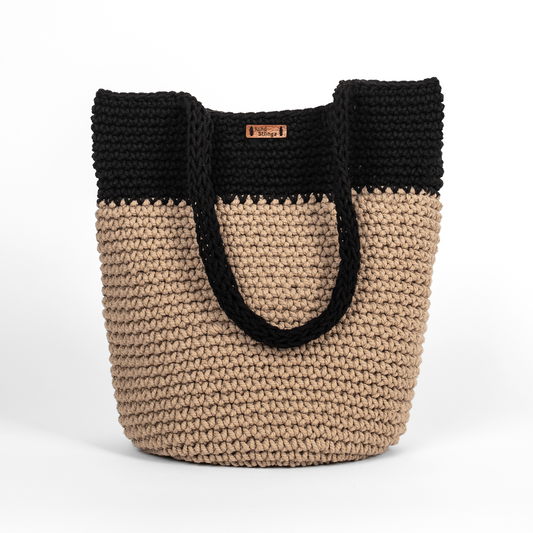 Two-toned black and beige woven bag on a white background