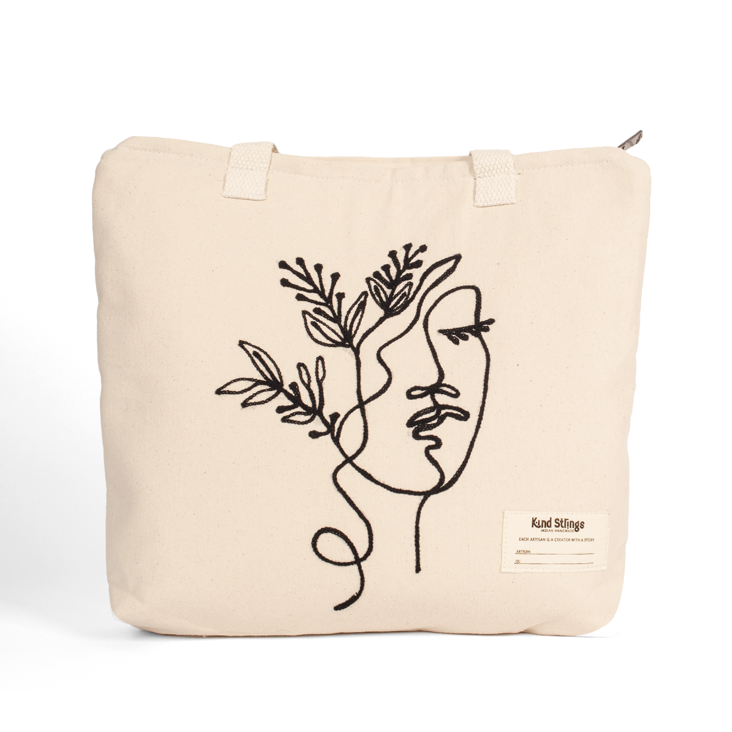 White tote bag with a face and floral design on a white background