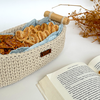 Woven basket with crackers on a surface next to an open book