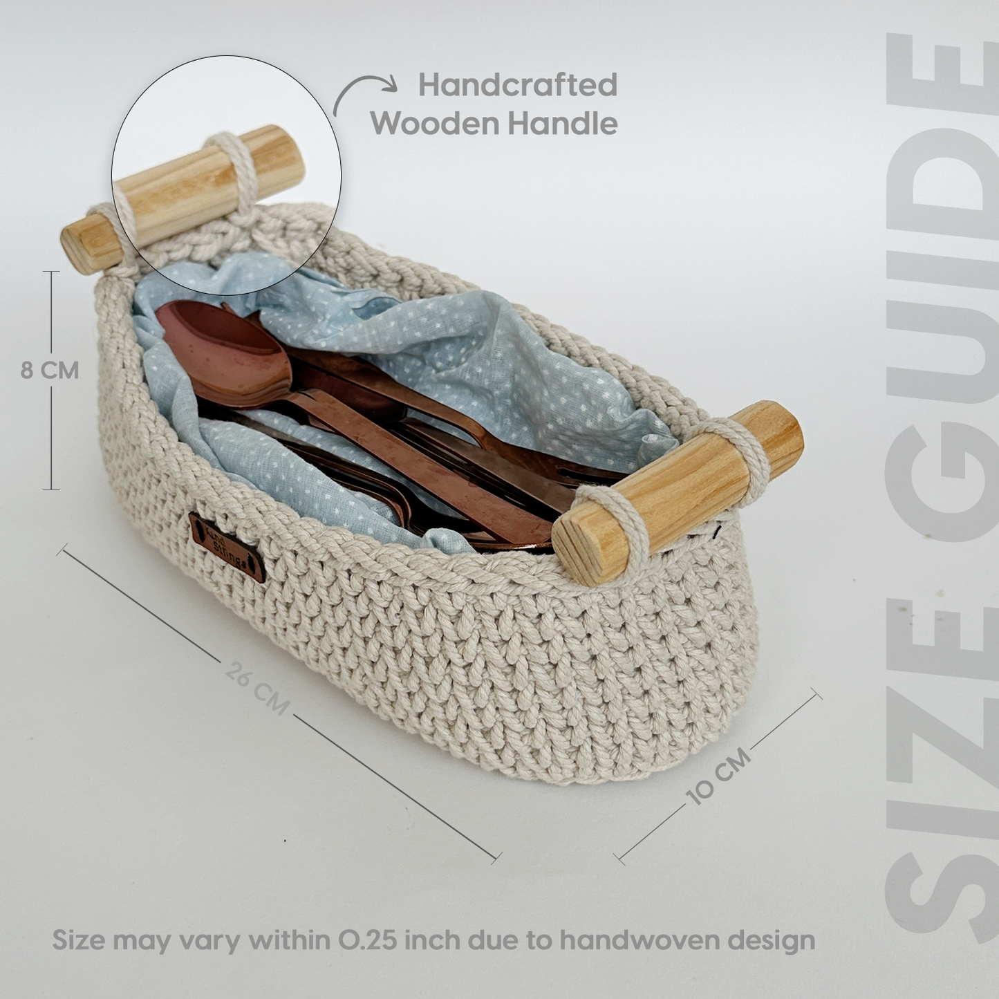 Woven basket with wooden handle containing cutlery and a cloth, with measurements and text on a light gray background.